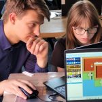 Twarze dwojga uczniów projektujących na laptopie w pracowni PAKT.