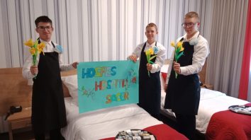 Uczniowie II klasy BS1S w zawodzie pracownik pomocniczy obsługi hotelowej promują zawód hotelarza trzymając plakat z główną maksymą hotelarstwa : „Hospes Hospiti Sacer” co znaczy „ Gość gospodarzowi święty”.
